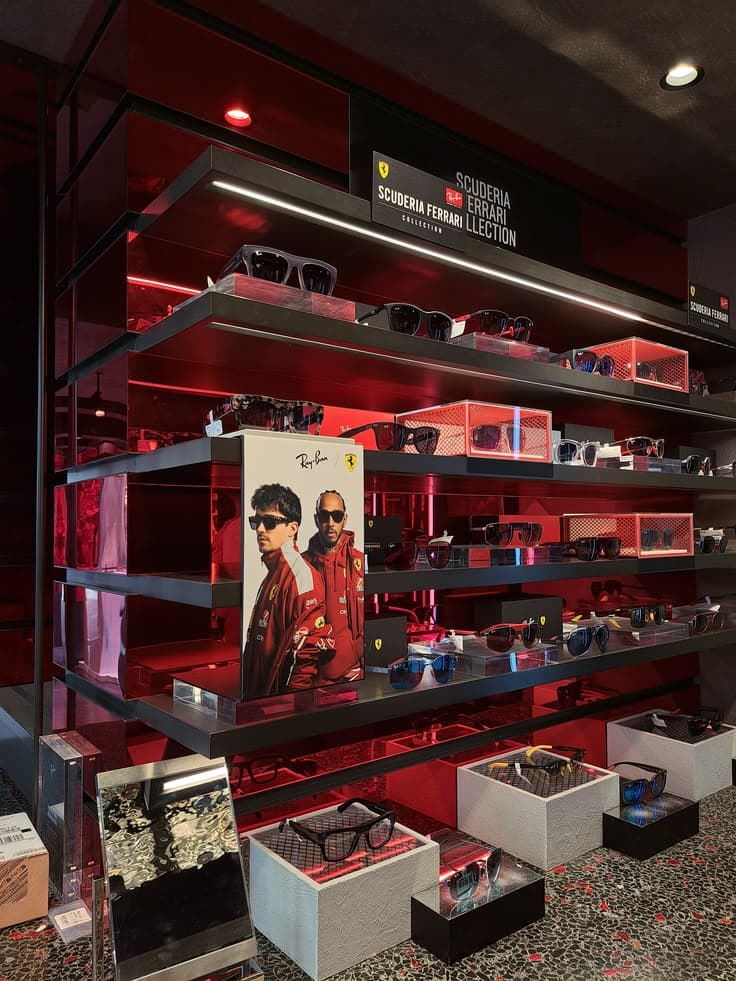 A red-lit sunglasses display wall in an opticians
